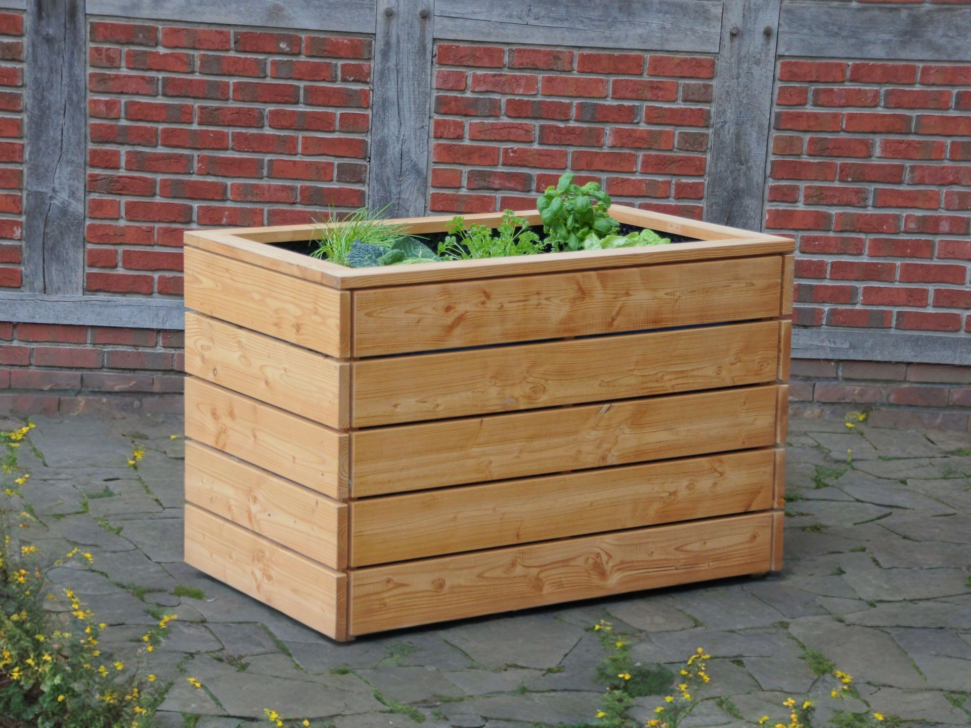 Hochbeet aus massivem Naturholz – praktisch im Alltag für frische Kräuter und Gemüse Hochbeet aus naturgeöltem Douglasienholz, auf Natursteinboden vor Fachwerkfassade, bepflanzt mit Kräutern und Salat