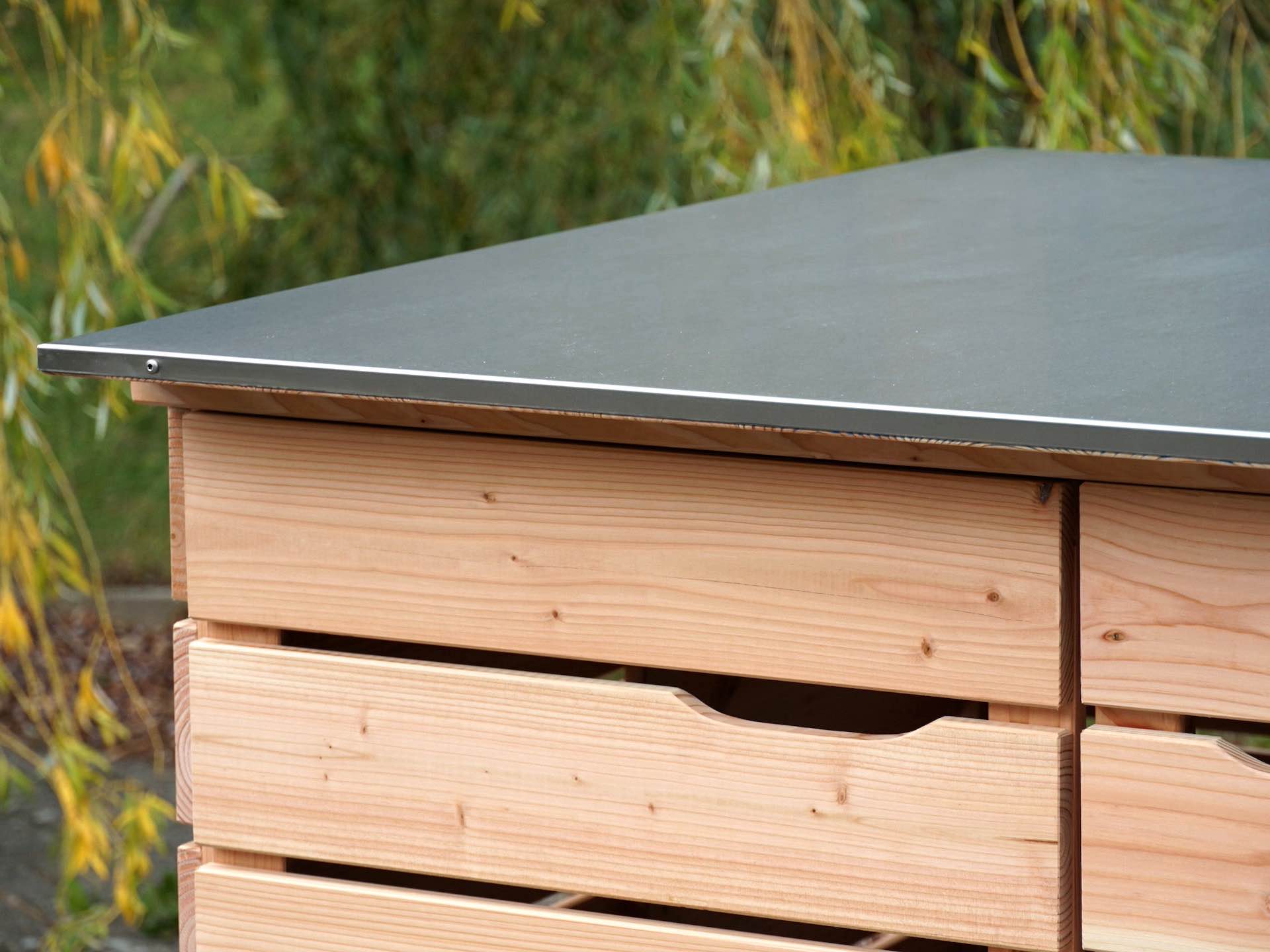 Detailansicht der linken Tür und Edelstahl-Dachverkleidung der naturbelassenen Kinderwagenbox