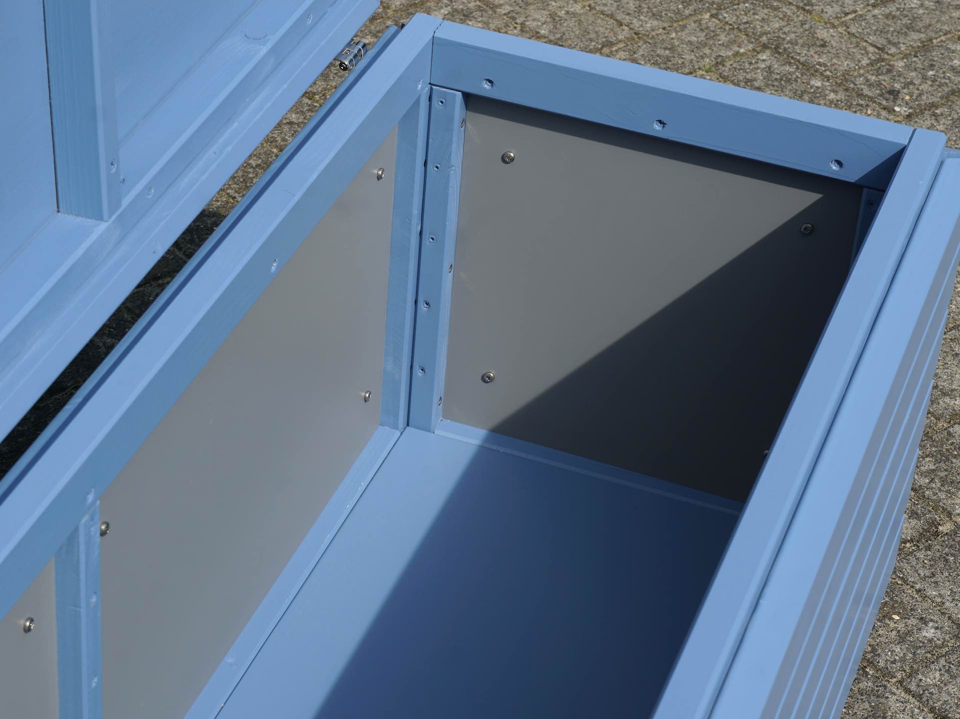 Blick in die Gartenbox – HPL-Innenverkleidung in Grau und robuster Holzboden	
