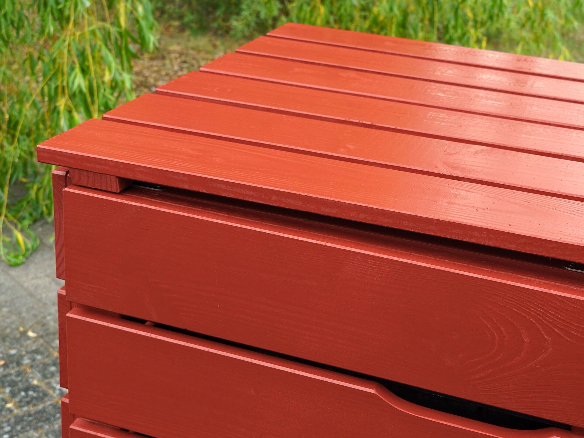 Detailaufnahme des linken Deckels und Tür-Ausschnitts der Mülltonnenbox in Nordisch Rot