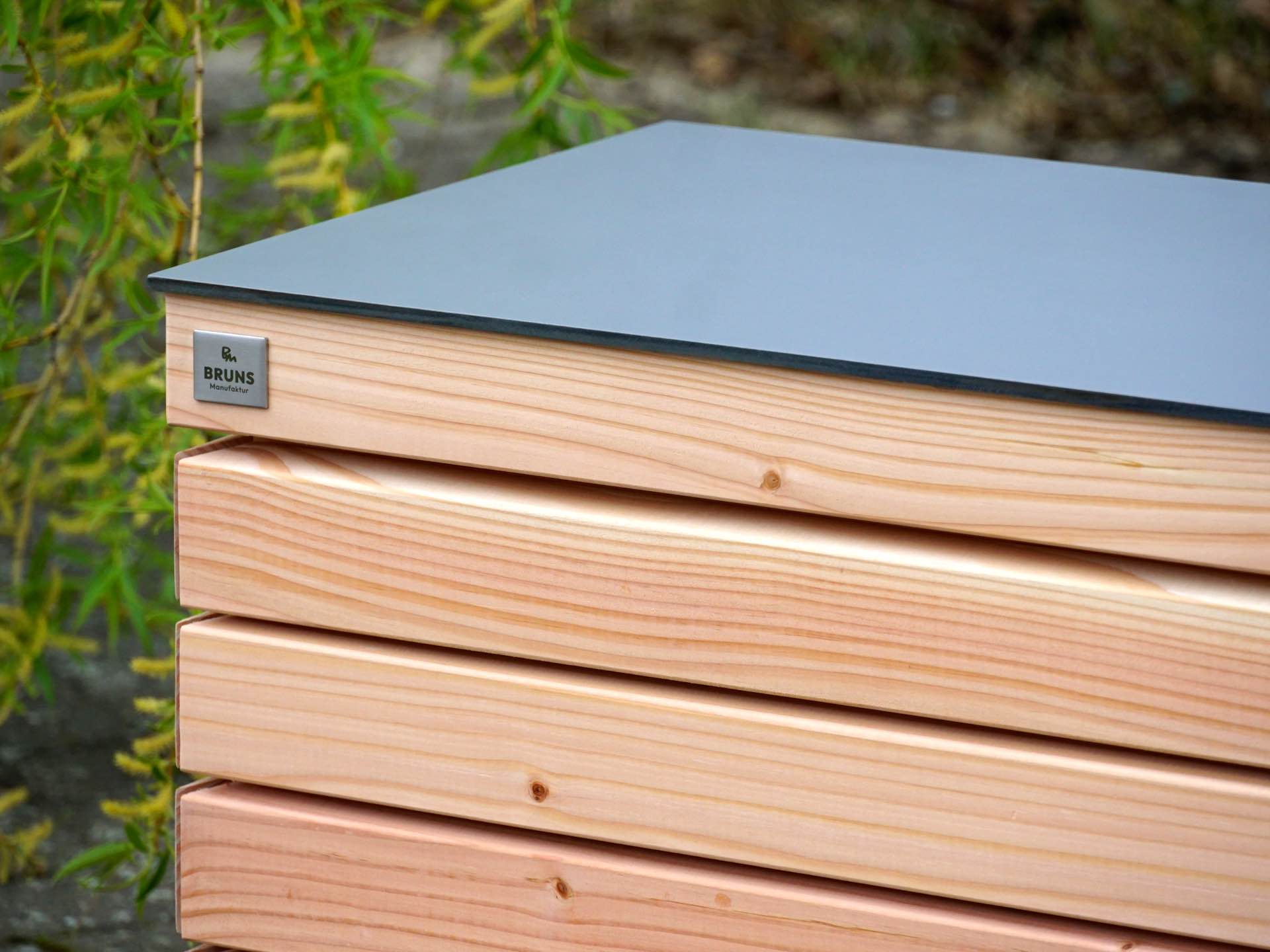 Kompakte Gartenbox Rhombus in Douglasie Natur – linke obere Ecke im Detail mit präzisem Fugenbild und HPL-Deckel in Mittelgrau	