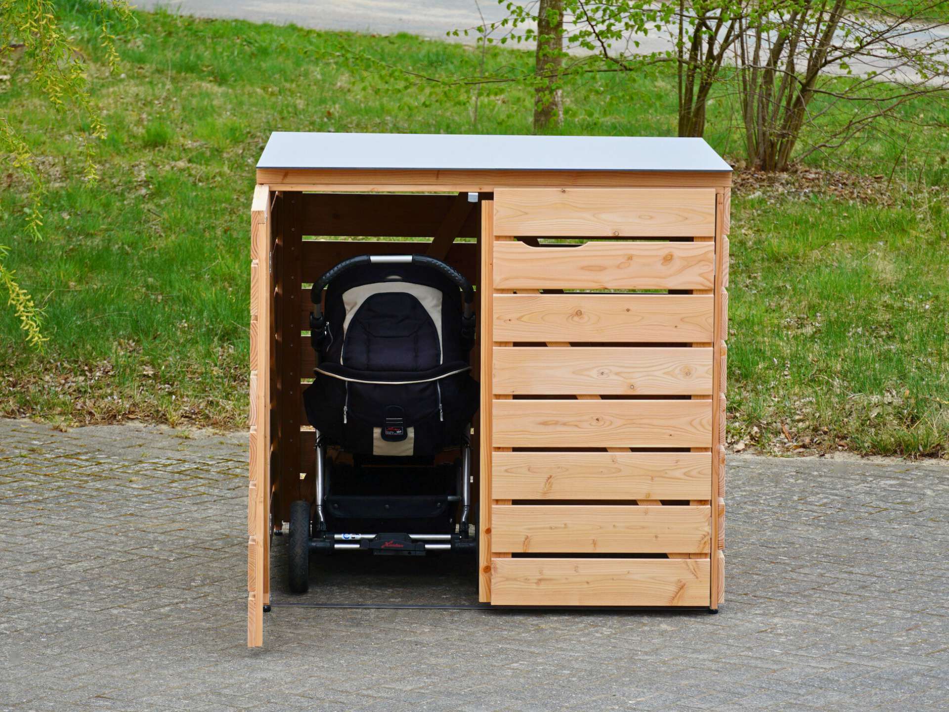Frontalansicht der Box mit geöffneter linker Tür und sichtbarem Kinderwagen