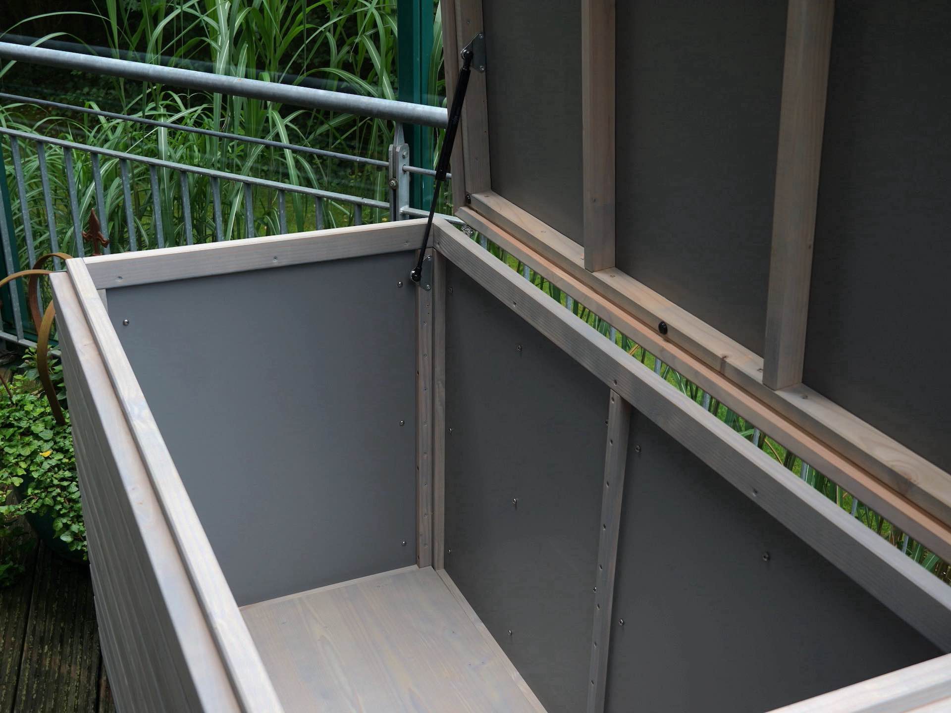 Innenansicht der Gartenbox in Grau Geölt – Stabiler Boden - Verkleidung aus HPL-Platte an Seitenwänden sichtbar	