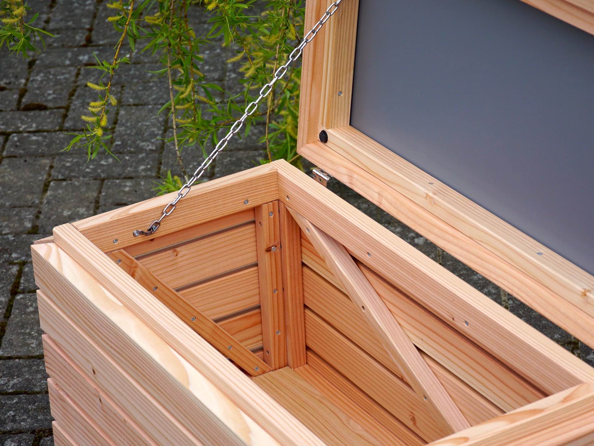 Blick in die kompakte Gartenbox – stabiler Holzboden für trockene und saubere Aufbewahrung	