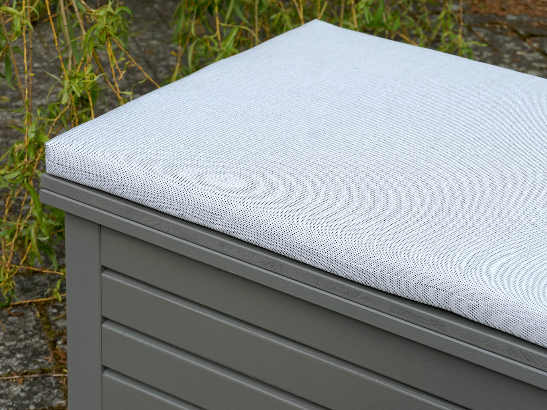 Gartenbox in Grau mit Massivholzdeckel und hellgrauem Polster – Detail oben links	