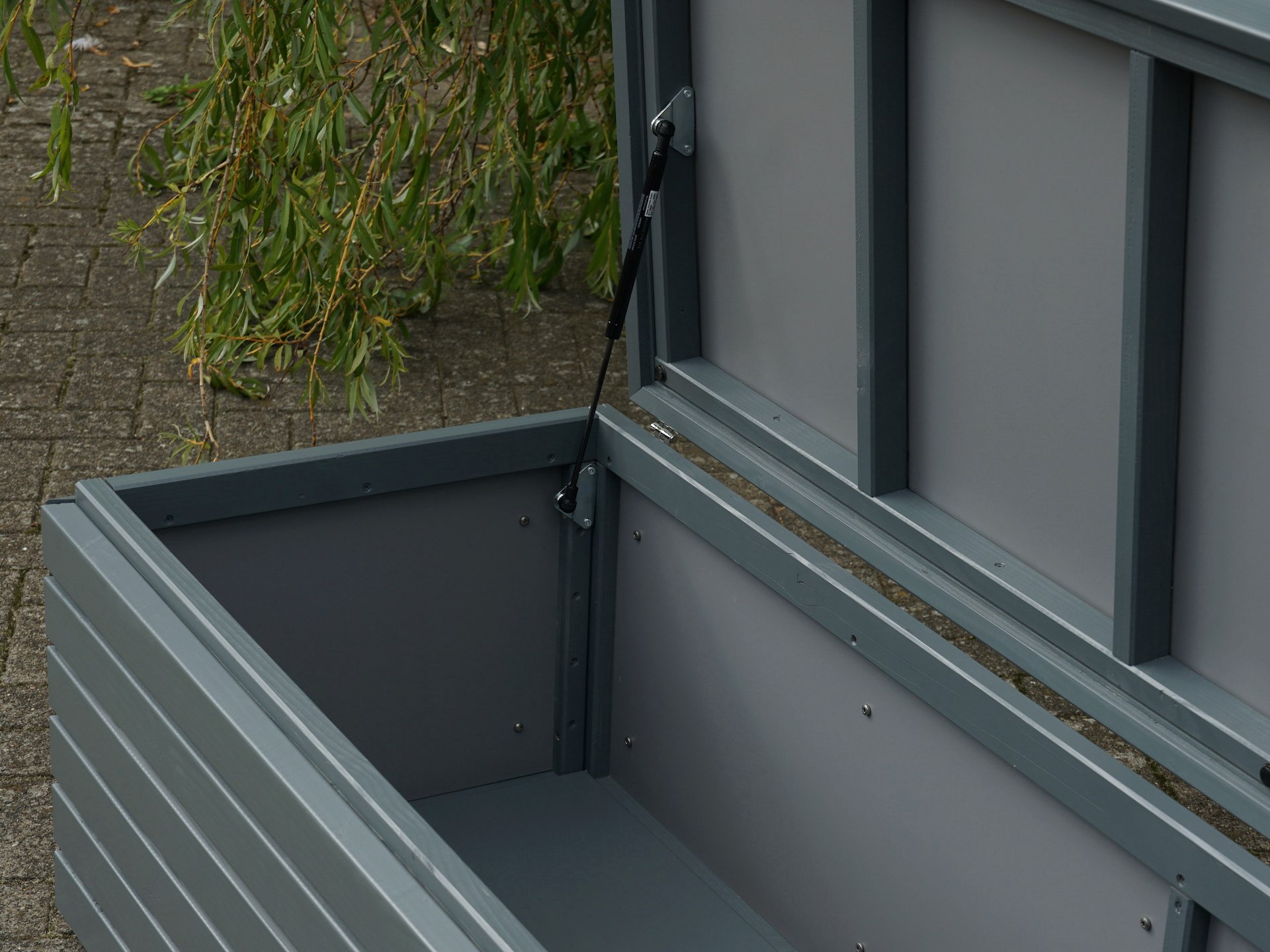 Blick in die Gartenbox in Grau – Innenverkleidung aus HPL und robuster Boden	