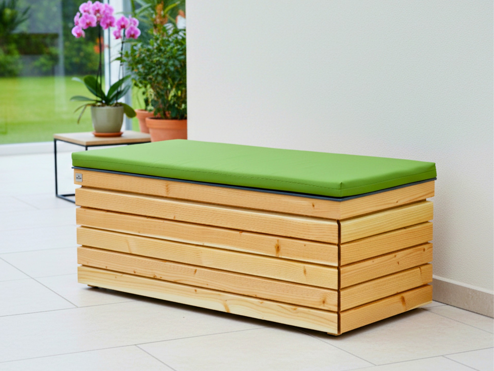 Sitztruhe Rhombus 120 aus geölter Douglasie mit Stauraum und hellgrünem Polster für Innen- und Außenbereiche.