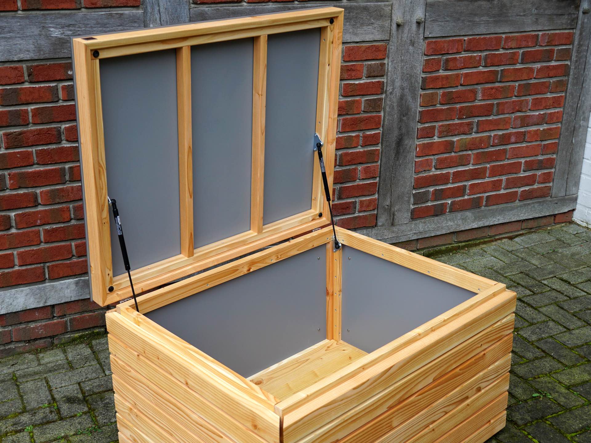 Blick in die Gartenbox – Innenverkleidung in grauer HPL-Platte mit stabilem Holzboden	