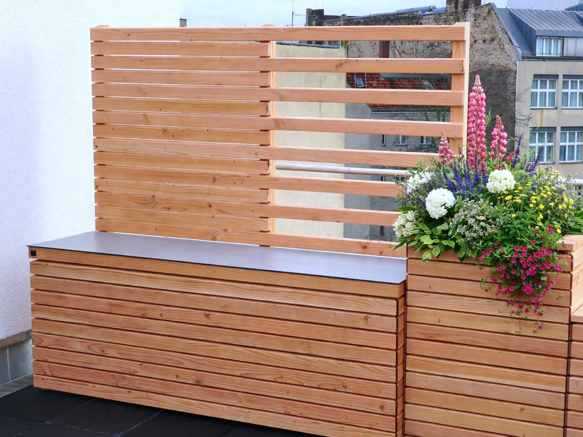 Gartenbox mit integriertem Sichtschutz und hohem Pflanzkasten als Kombination aus Stauraum, Privatsphäre und Begrünung.