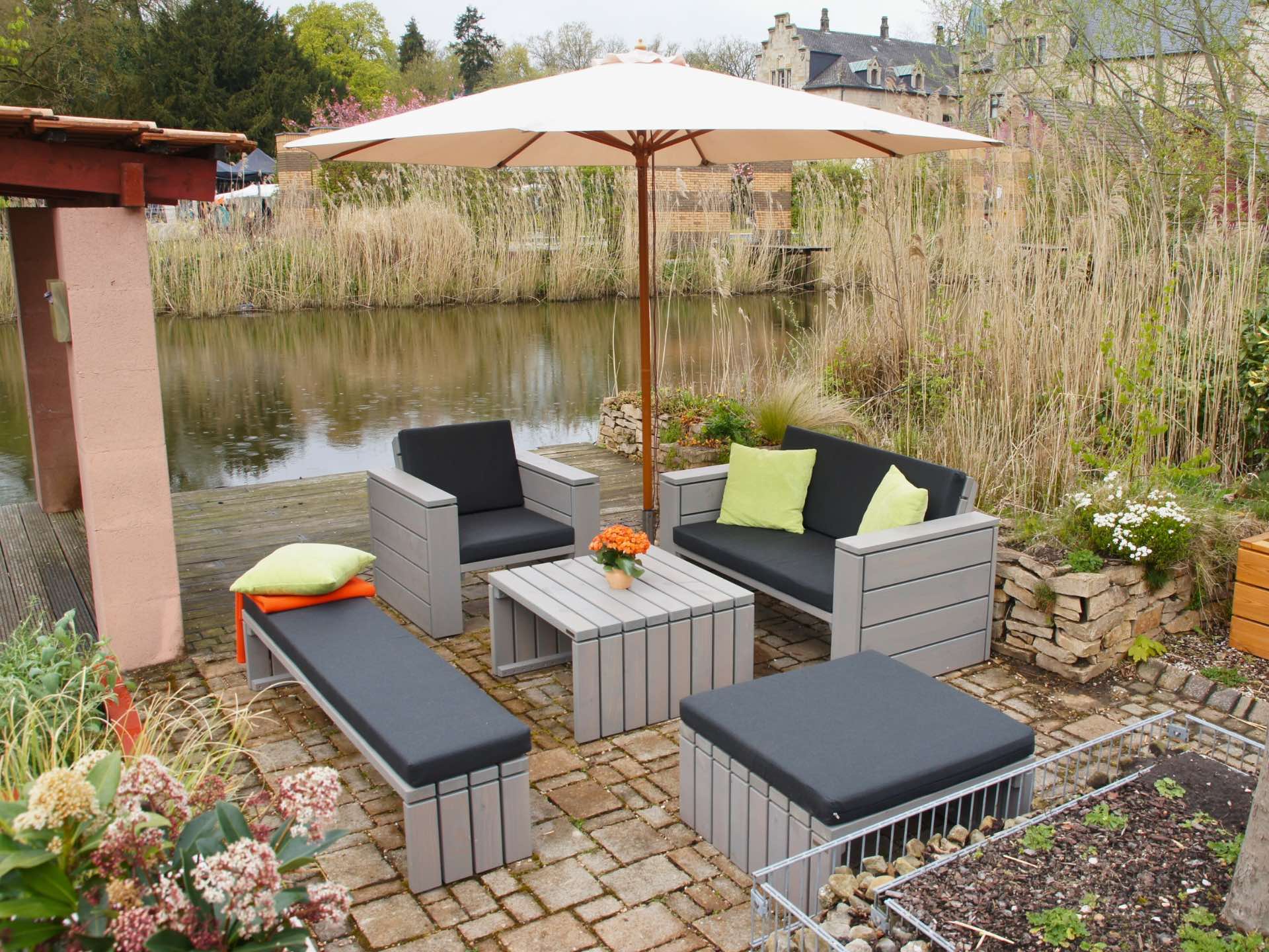 Loungemöbel Set in Grau geölt mit anthrazitfarbenen Polstern, bestehend aus Tisch, Hocker, Sessel, Sofa und Bank.