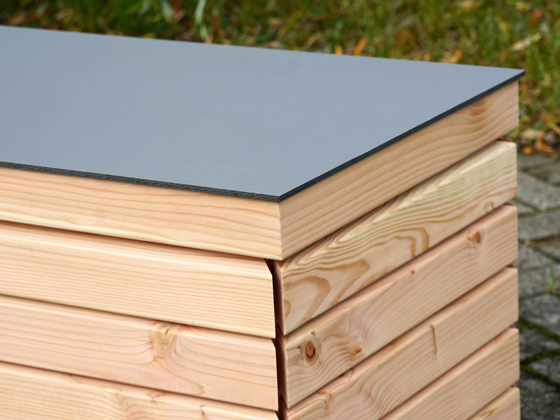 Gartenbox Rhombus Douglasie Natur – rechte obere Ecke mit harmonischem Zusammenspiel von Holzstruktur und HPL-Oberfläche	