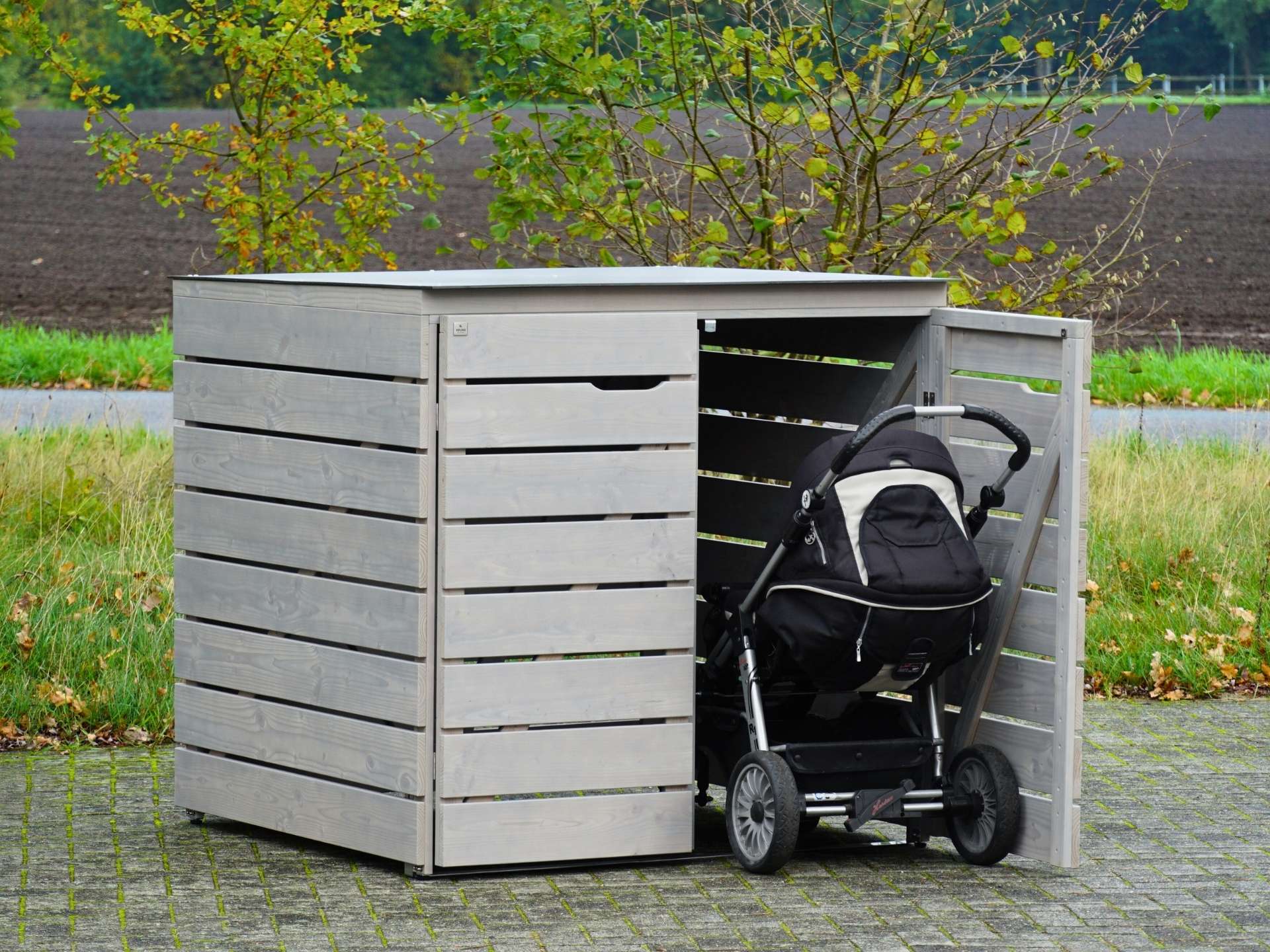 Kinderwagen-Garage in Aktion – eine Tür offen, Kinderwagen im Einstellvorgang