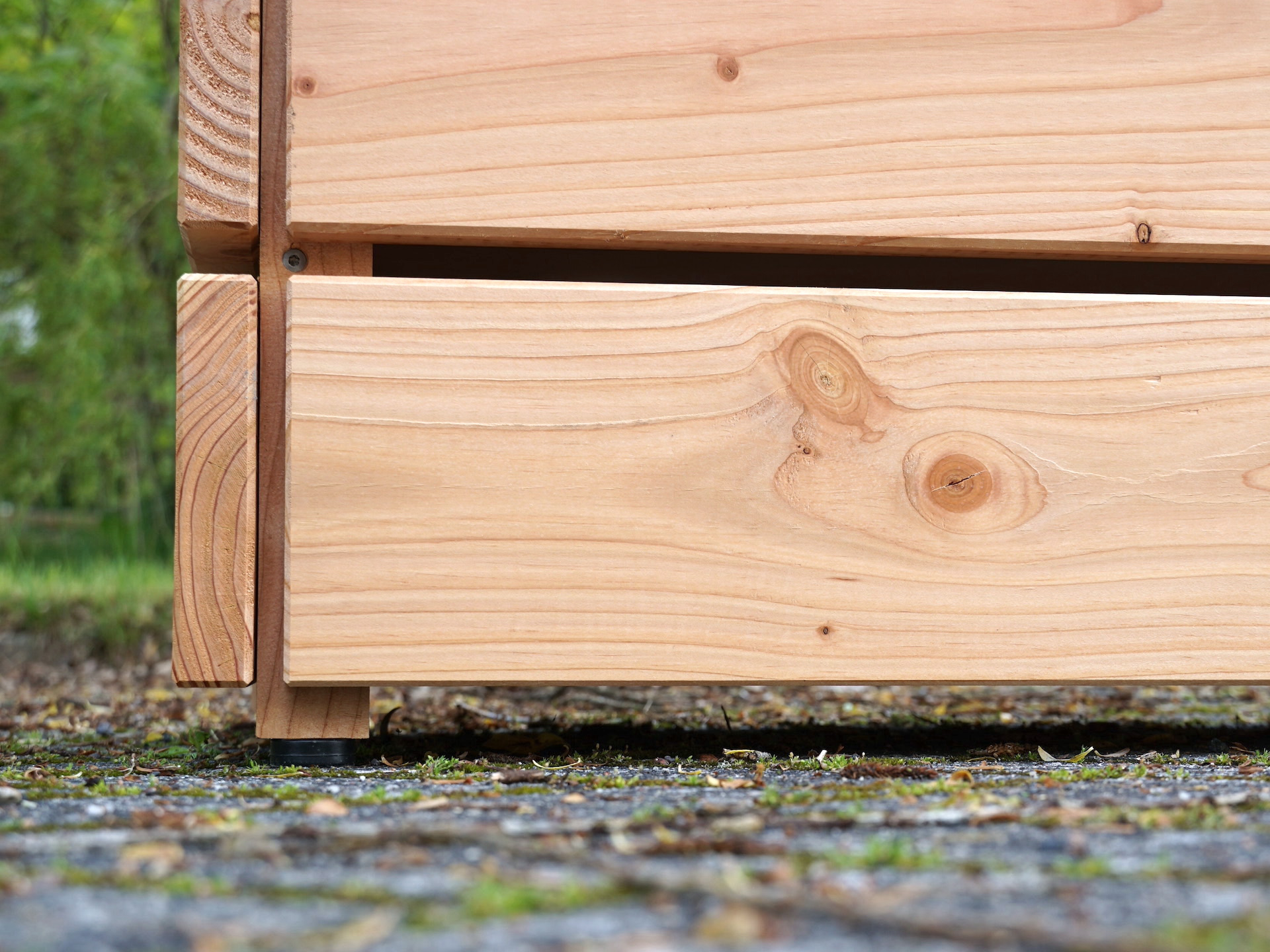 Fußpunkt eines Pflanzkastens mit Kunststoff-Möbelfuß als Holzschutz