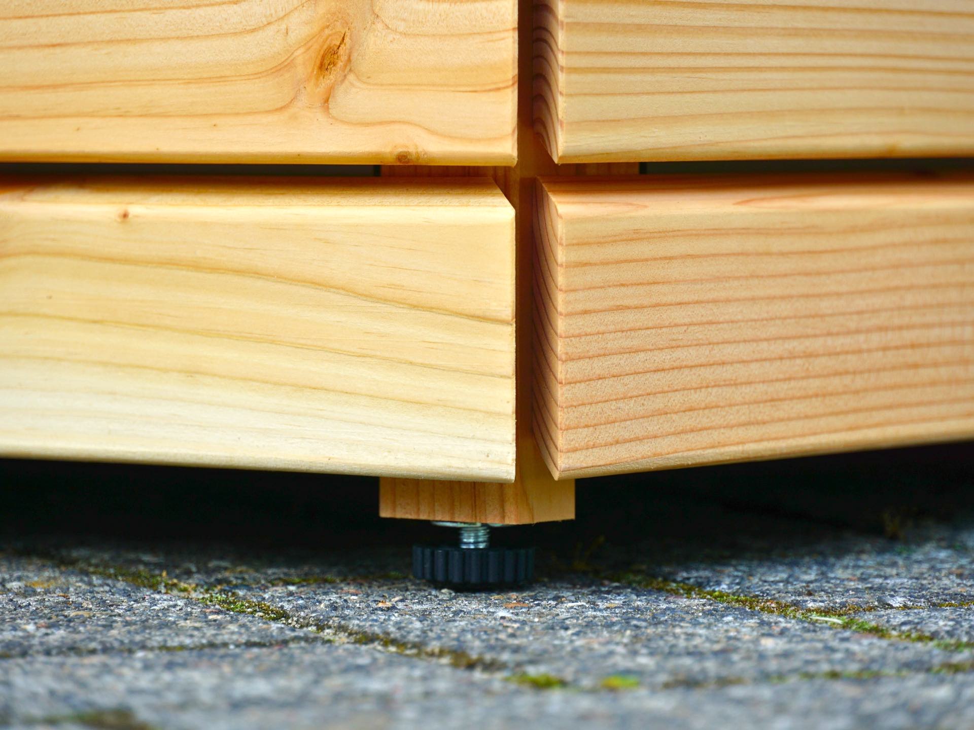 Detailansicht des höhenverstellbaren Nivellier-Fußes der Sitztruhe Rhombus 120 – ausgleichend auf unebenem Untergrund