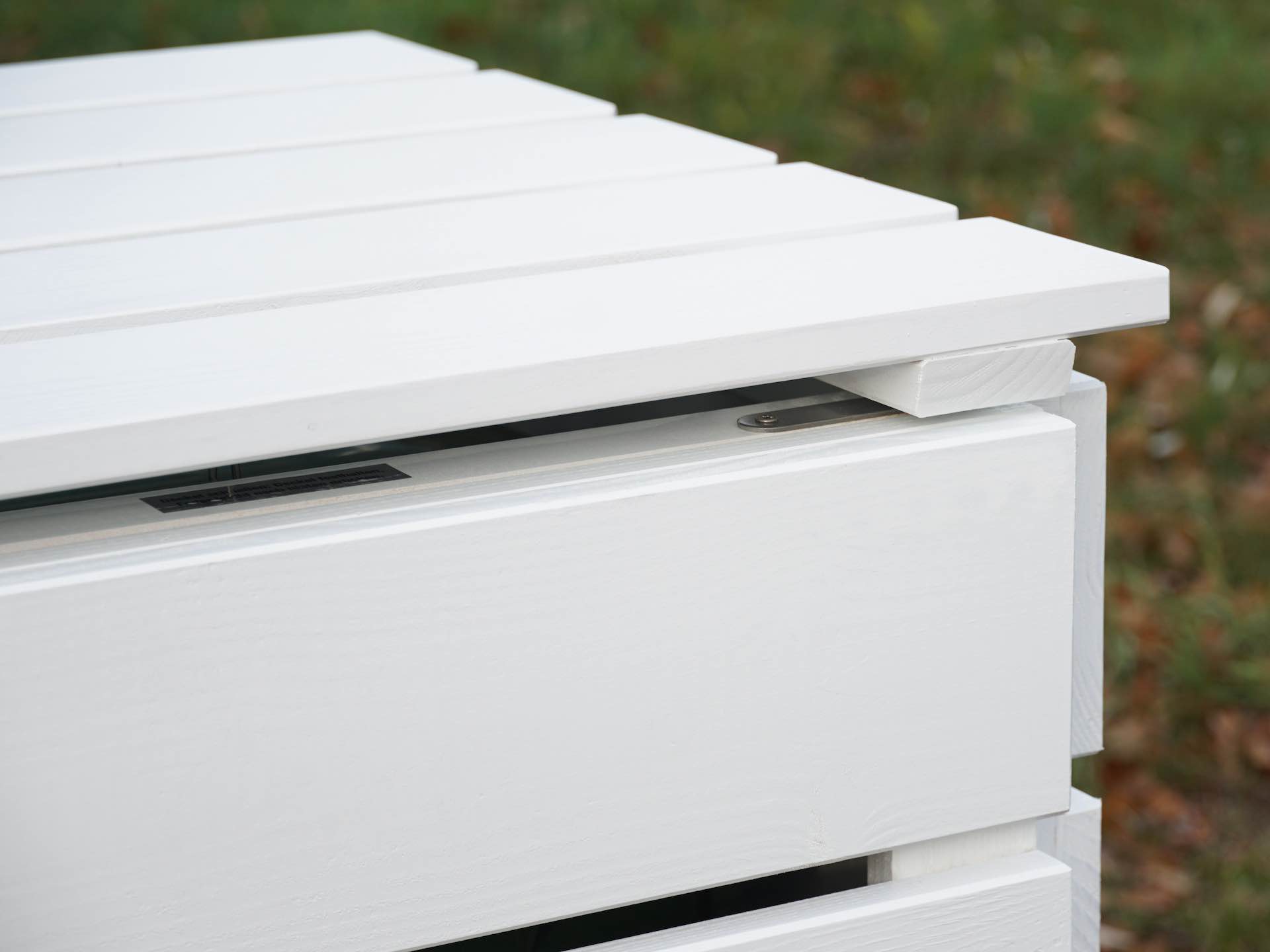 Detailaufnahme von Deckel und Türausschnitt der Mülltonnenbox in Weiß