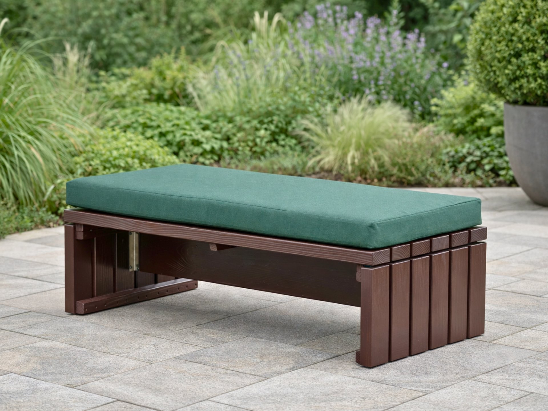 Lounge Hocker in Dunkelbraun mit dunkelgrünem Polster als flexible Ergänzung für die Outdoor-Lounge.