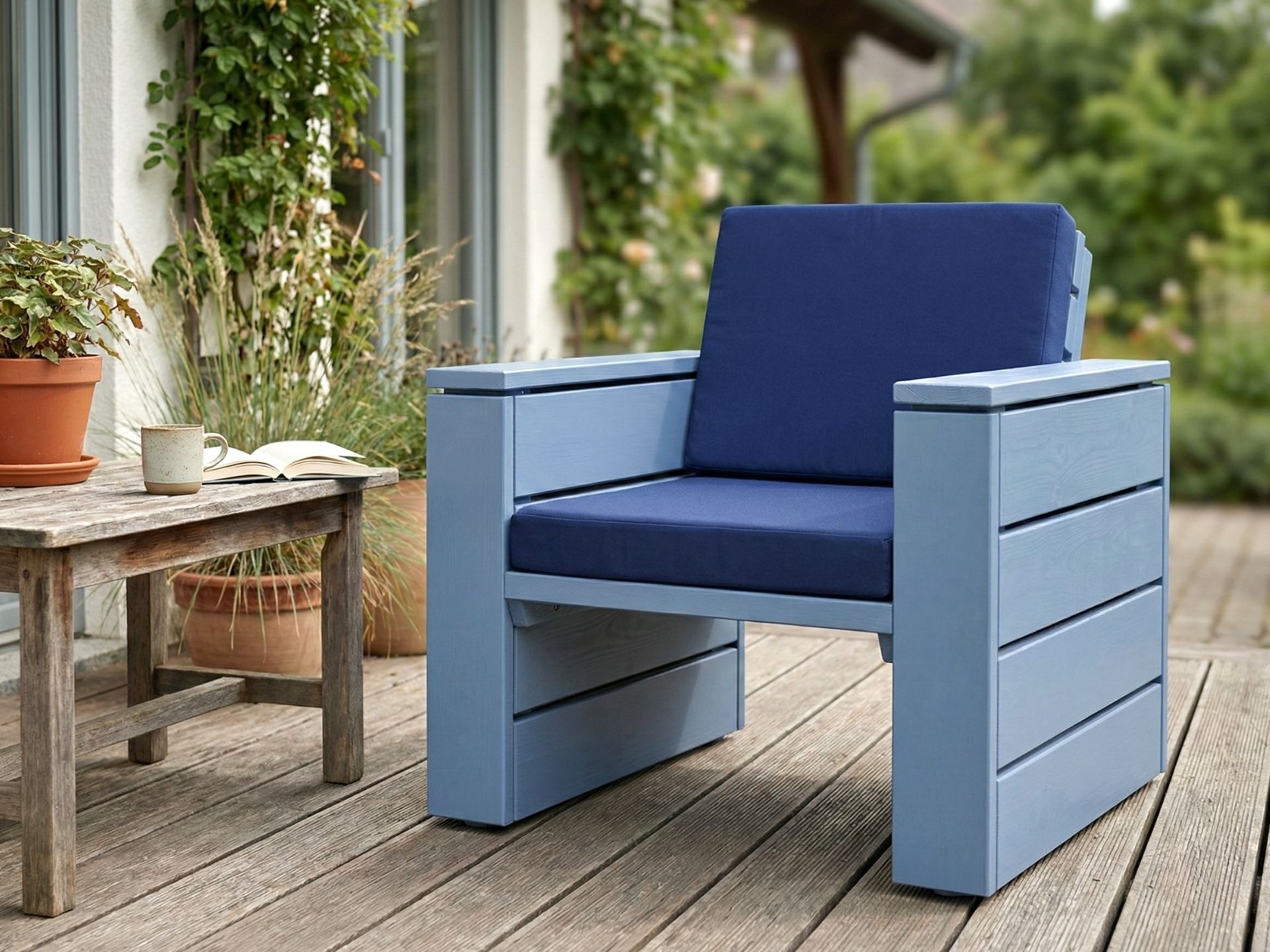 Lounge Sessel 60 in Taubenblau mit dunkelblauem Polster als Farbakzent in einem modernen Gartenkonzept.