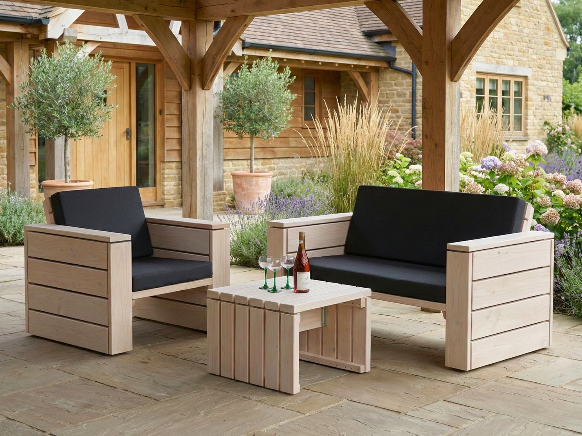 Loungemöbel Set in Weiß Geölt mit anthrazitfarbenen Polstern auf gemütlicher Terrasse.