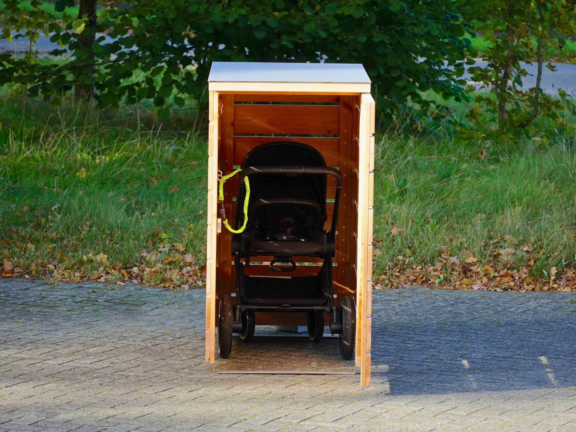 Kinderwagenbox mit geöffneter Tür, frontal aufgenommen, mit Kinderwagen