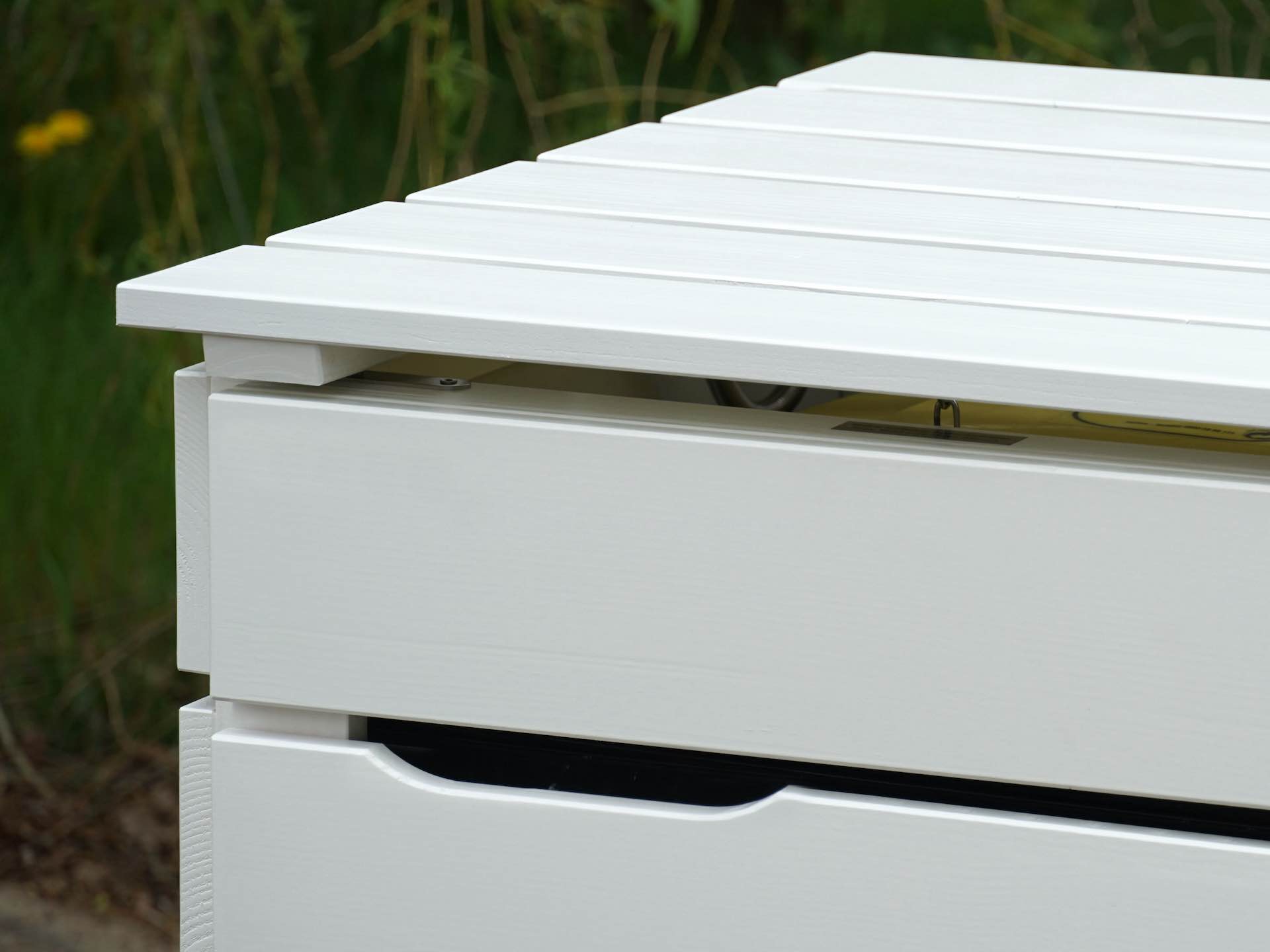 Detailaufnahme von Deckel und Türausschnitt der weißen Mülltonnenbox