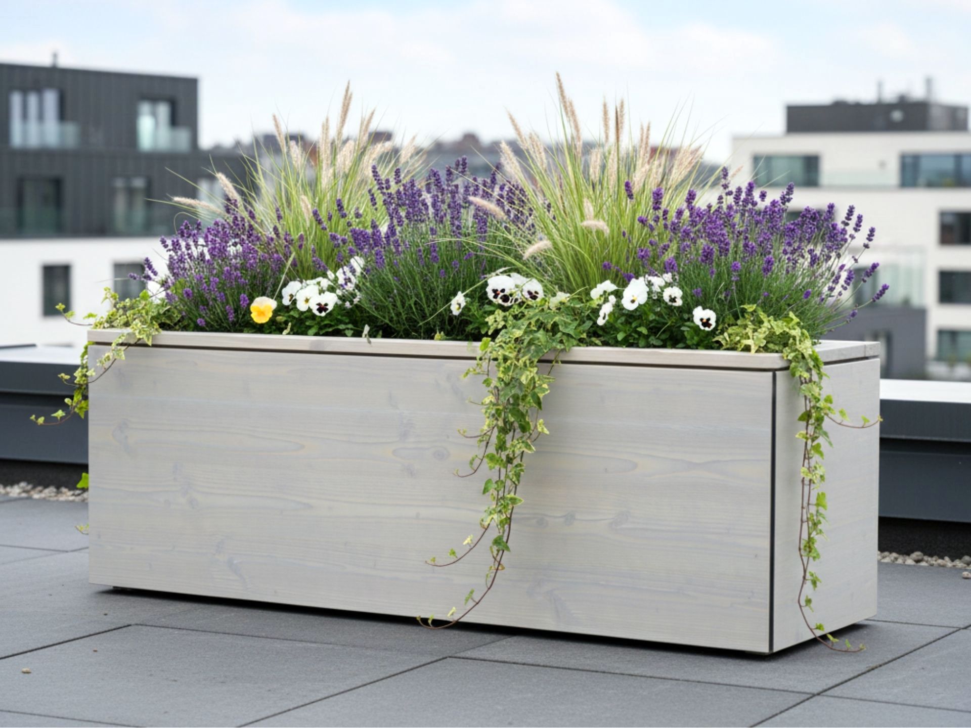 Maßgefertigter Pflanzkasten Cubus in Grau Geölt auf einer Dachterrasse, individuell angepasst an Fläche und Nutzung.