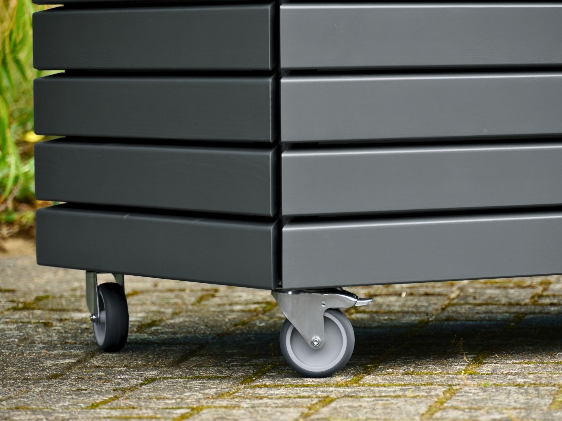 Detailansicht der Lenkrollen an der Gartenbox in Basaltgrau – mit präzise gearbeiteten Rhombusleisten und Gehrungsschnitt