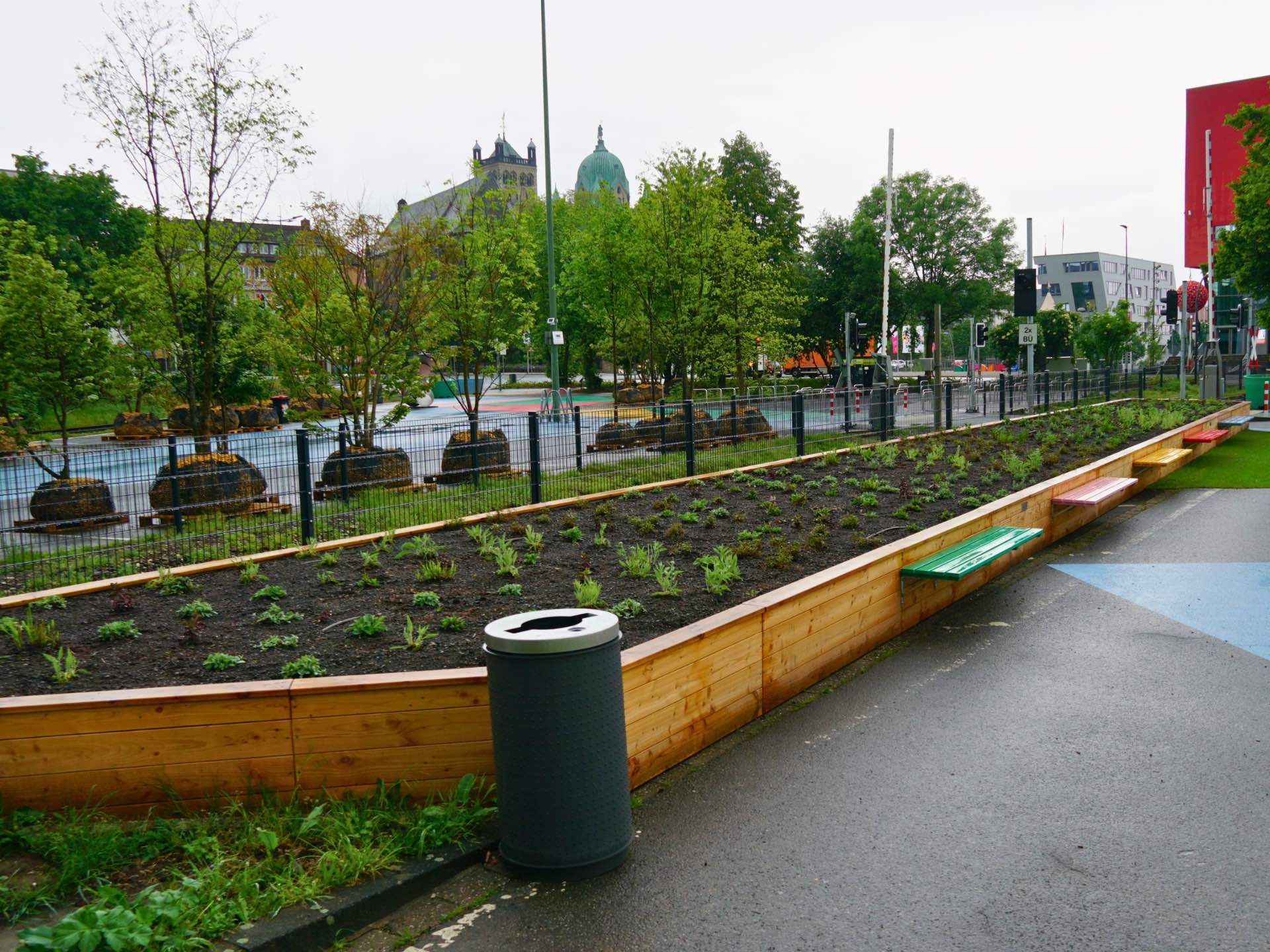Großes polygonales Hochbeet aus Holz mit bunten Sitzbänken auf dem Gelände der Landesgartenschau Neuss.