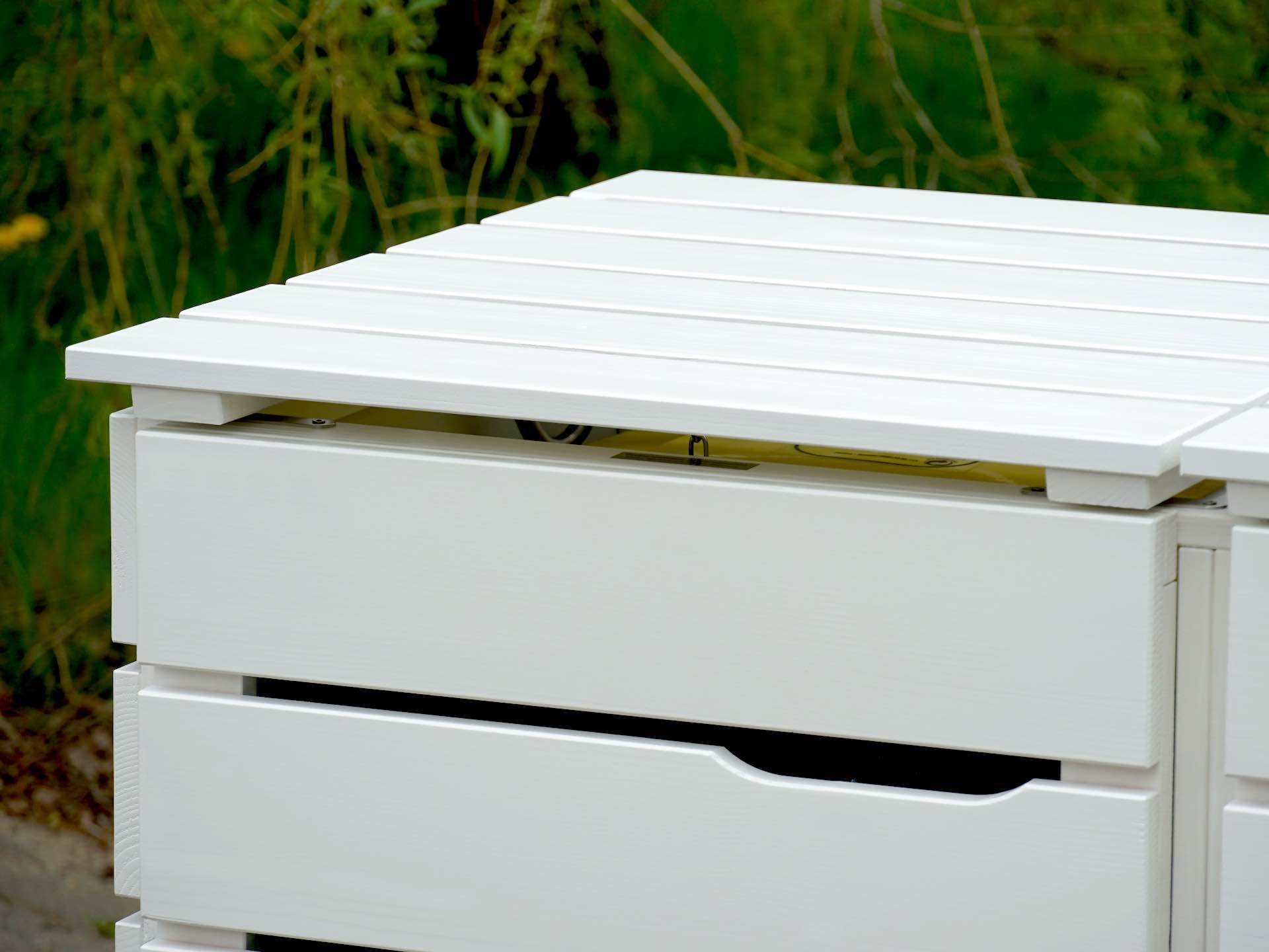 Detailaufnahme von Deckel und Türausschnitt der weißen Mülltonnenbox