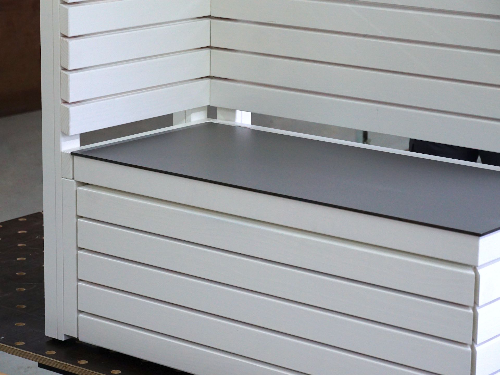 Detailansicht der Gartenbox Rhombus 110 in Weiß – Fokus auf hellgraue HPL-Outdoorplatte und präzise Rhombusleisten mit klarer Linienführung