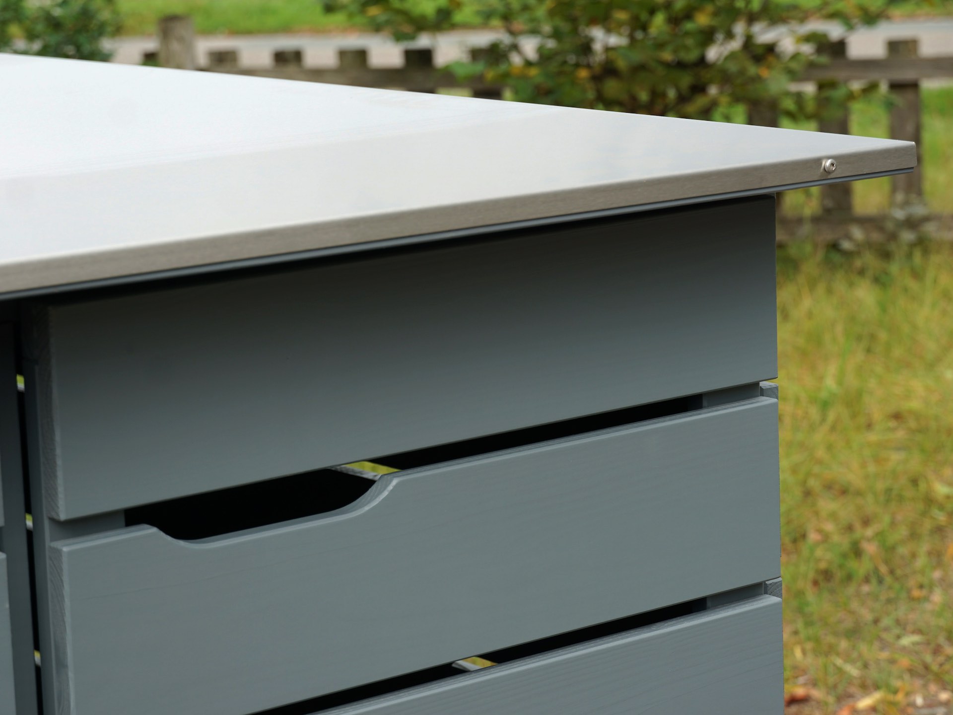 Kinderwagenbox Classic in Basaltgrau – Detail oben rechts mit sichtbarem Ausschnitt der rechten Tür und der gebürsteten Edelstahl-Dachverkleidung.	