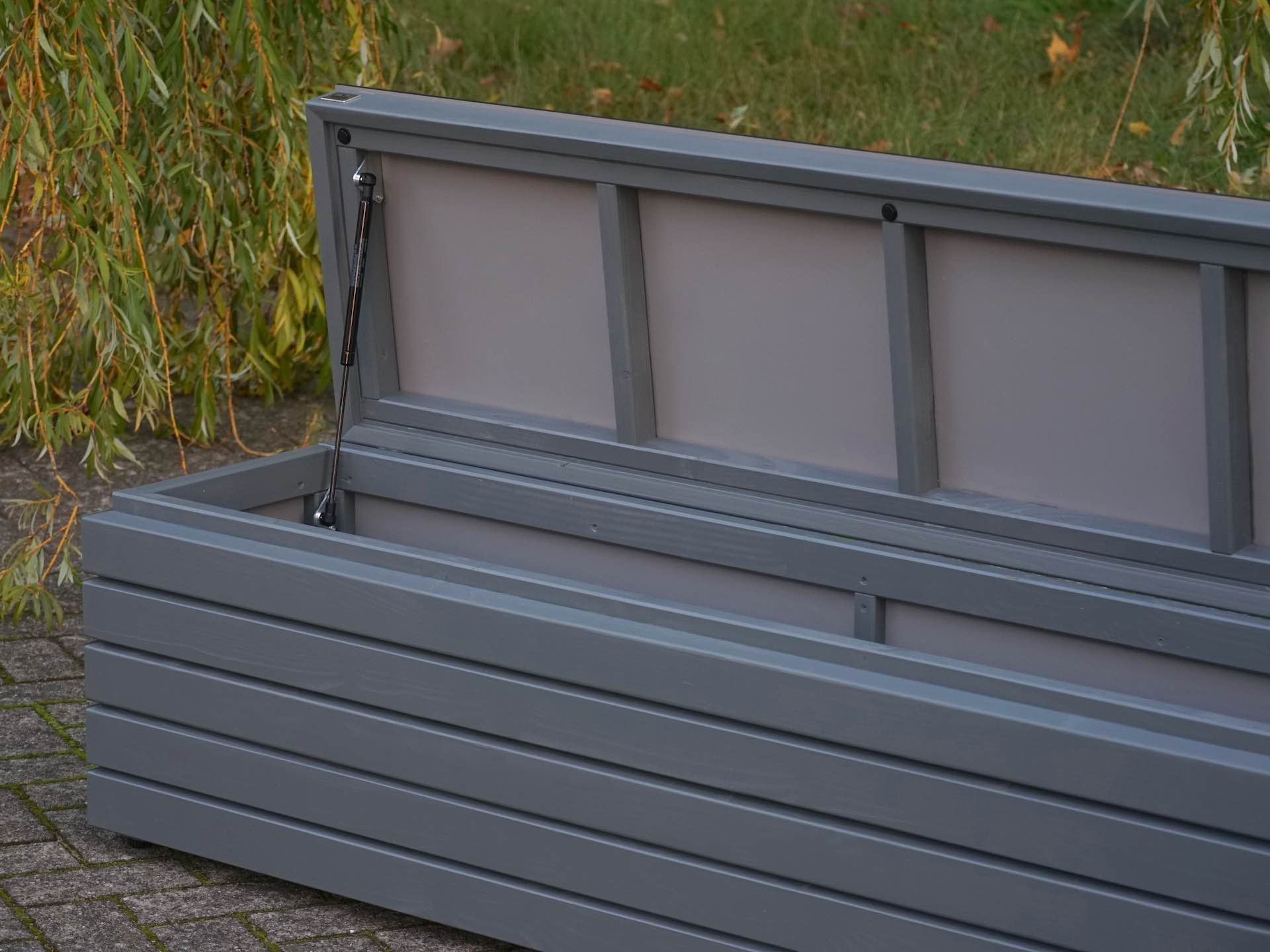 Gasdruckfeder im geöffneten Deckel der Gartenbox Rhombus – sicher und leicht zu bedienen	