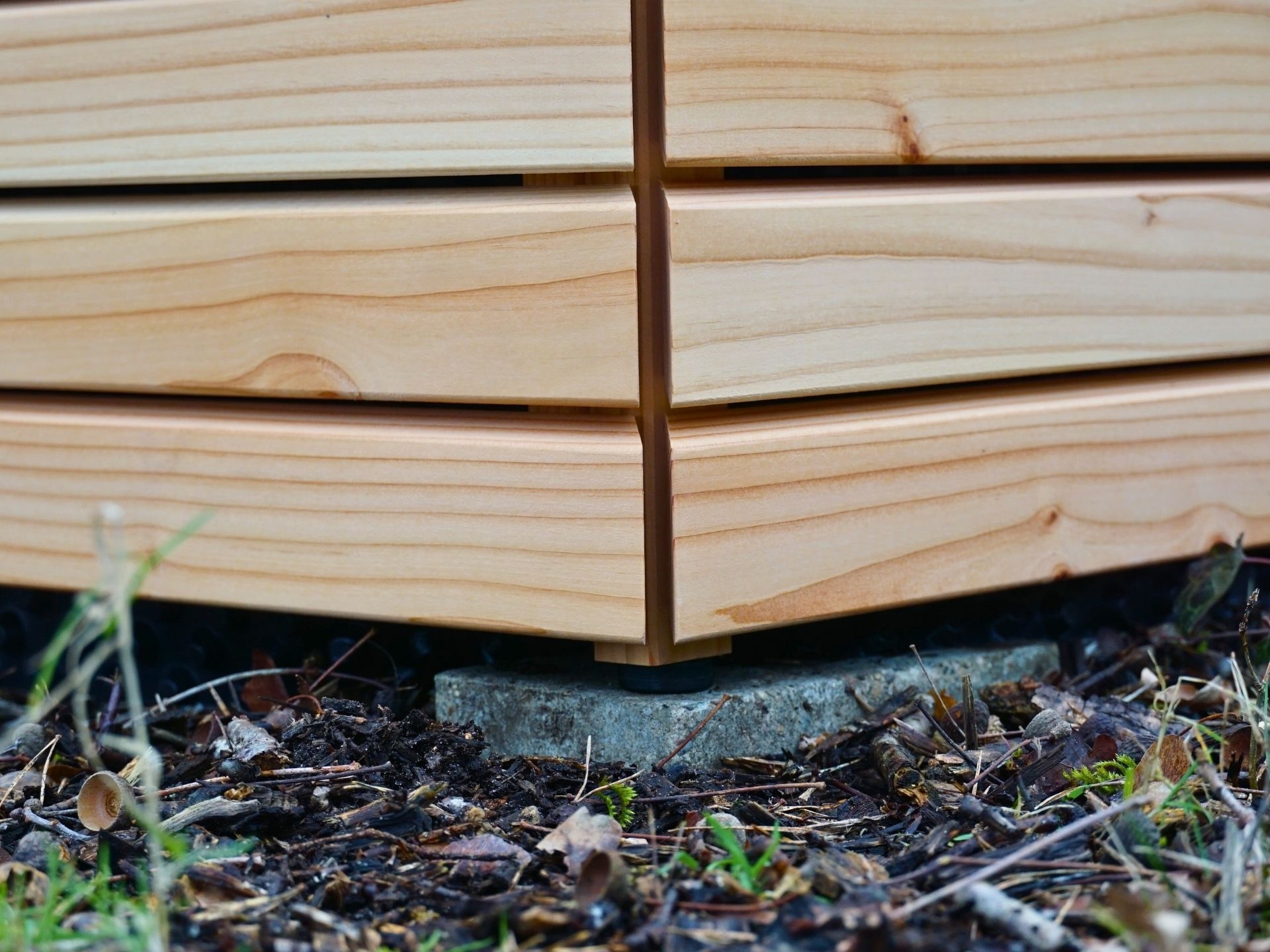 Detailaufnahme des Hochbeet-Fußes – Rhombusprofil in Natur Geölt mit 10 mm Kunststoff-Distanzscheibe zum Schutz vor Bodenfeuchte