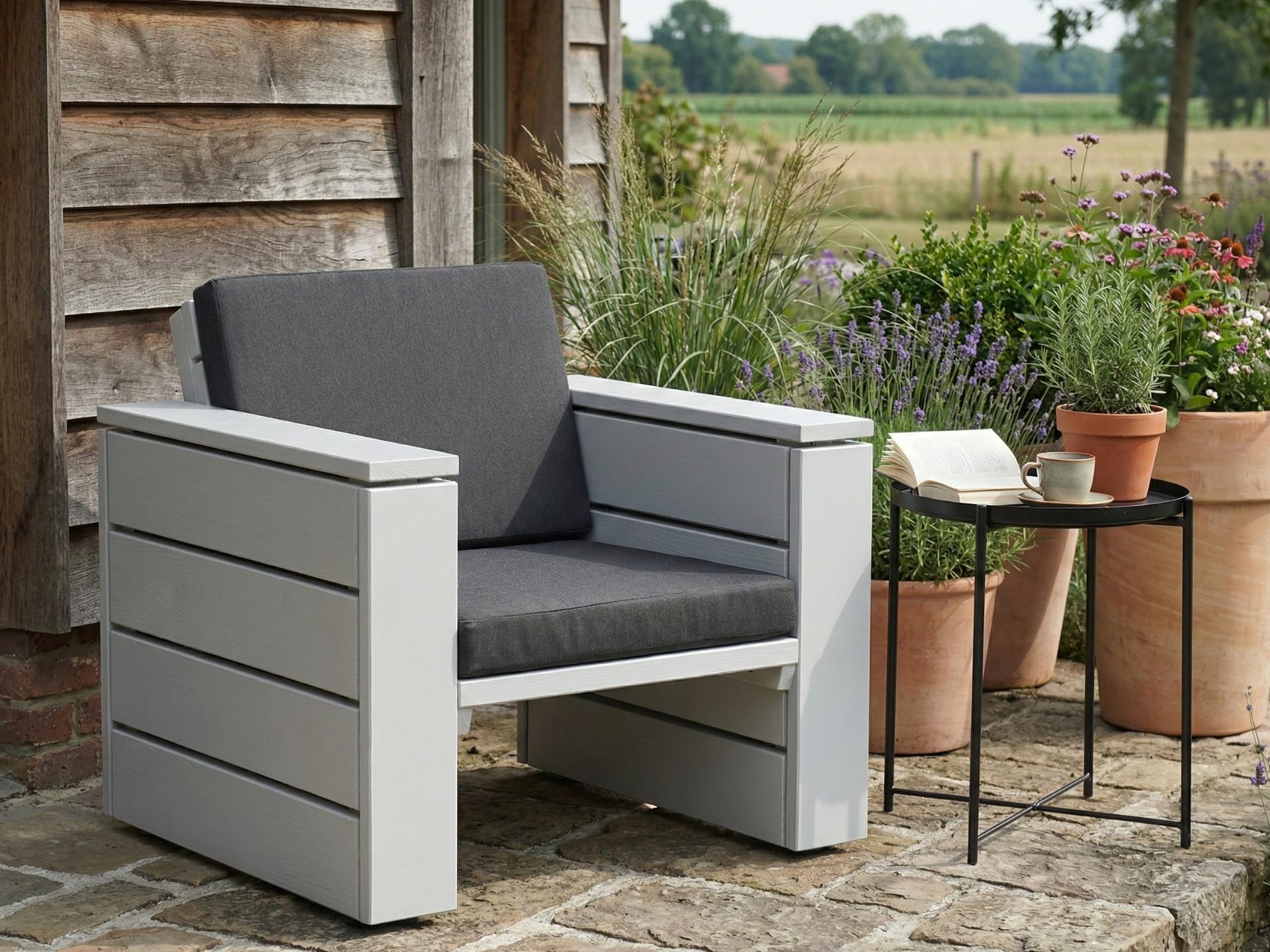 Lounge Sessel aus Holz in Lichtgrau mit anthrazitfarbenen Polstern vor einer modernen Hauswand.