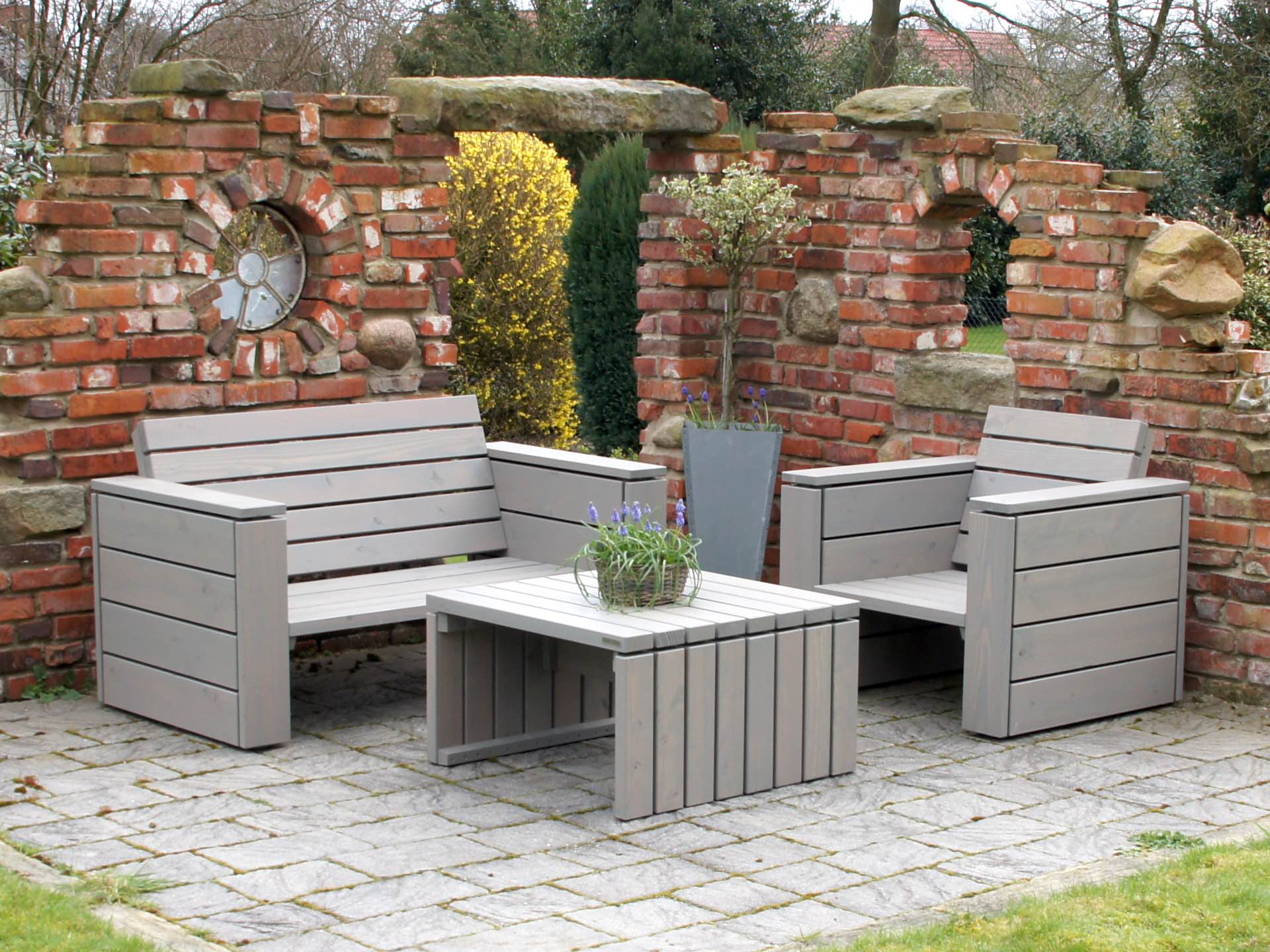 Loungemöbel-Set 1 aus massivem Douglasienholz grau geölt, Sofa, Tisch und Sessel ohne Polster, vor Klinkermauer
