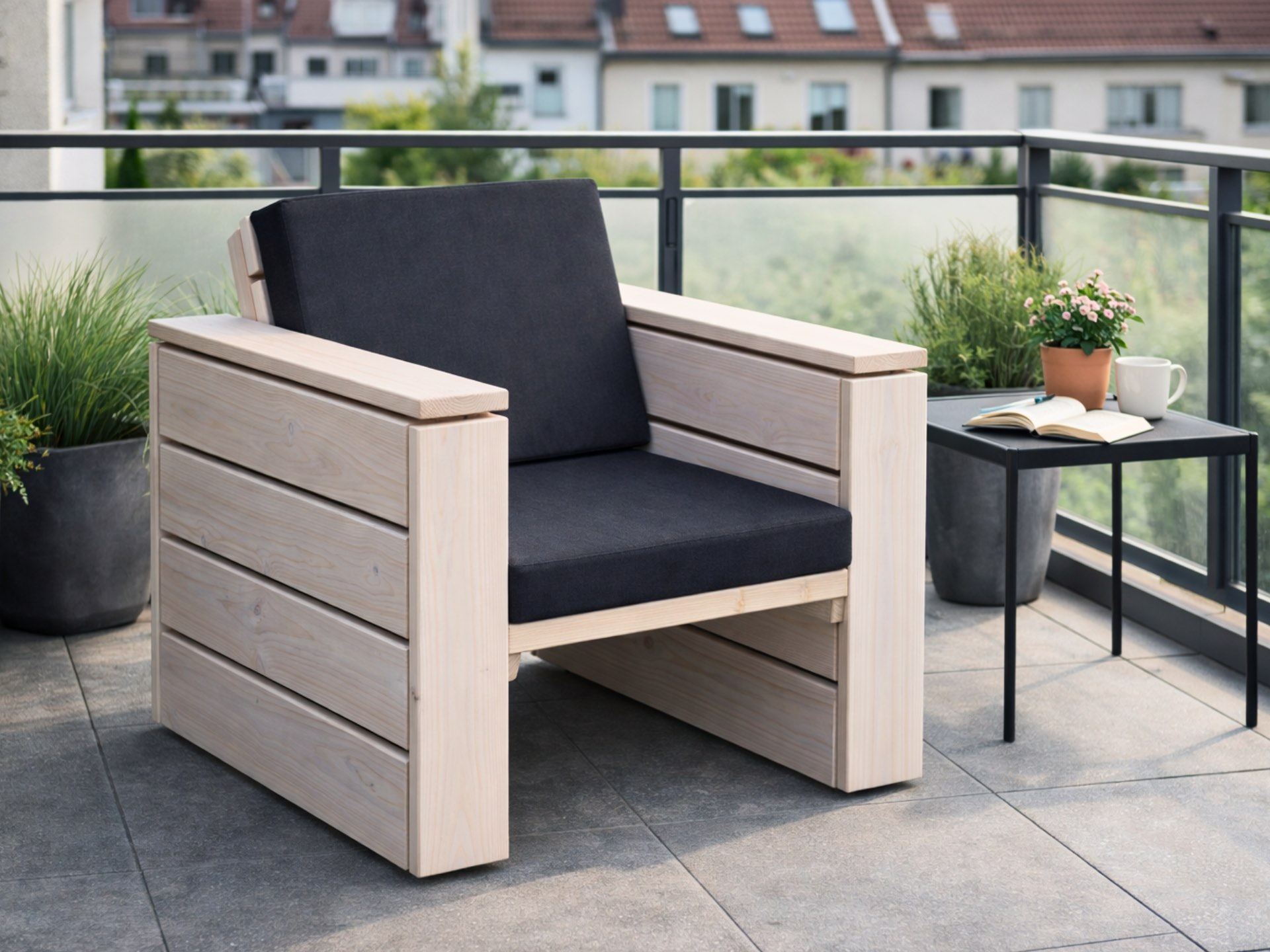 Lounge Sessel aus Holz in Weiß Geölt mit anthrazitfarbenen Polstern auf gemütlichem Balkon.