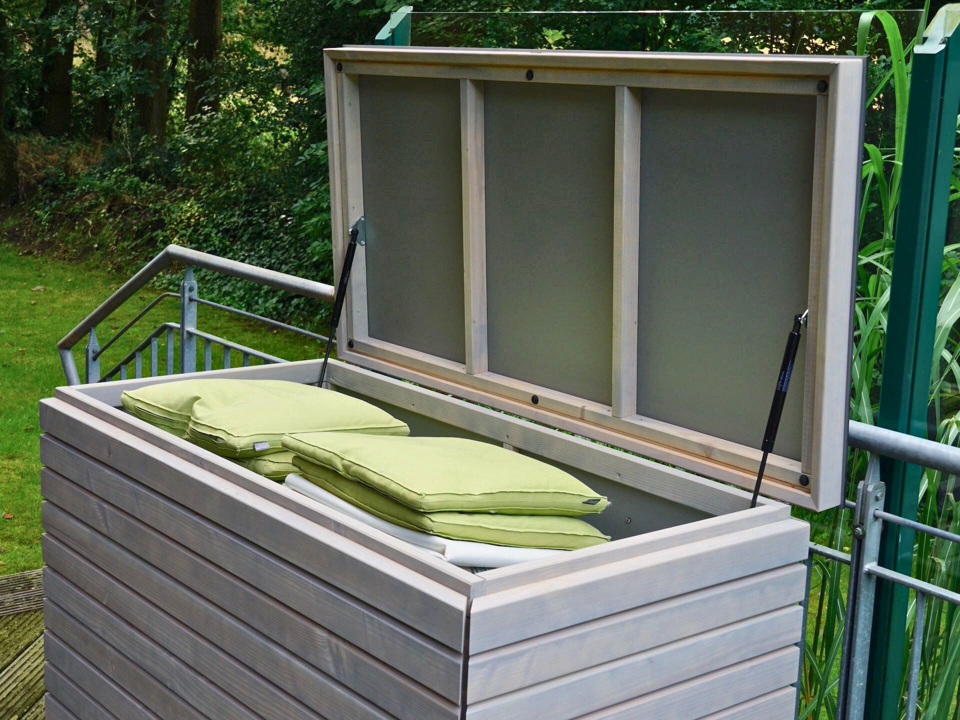 Gartenbox Rhombus in Grau Geölt – geöffnet, gefüllt mit Auflagen, Deckel mit Gasdruckfedern	