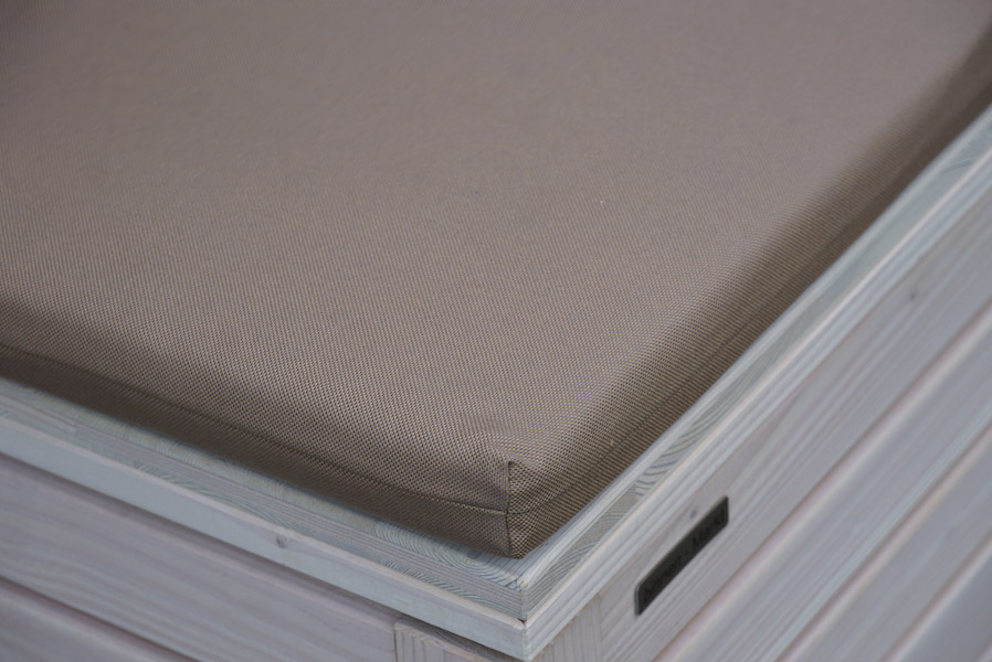 Polster in Dekor Sand – Detailansicht auf der weißen Sitztruhe Rhombus, mit Blick auf die vordere Ecke des Truhendeckels	