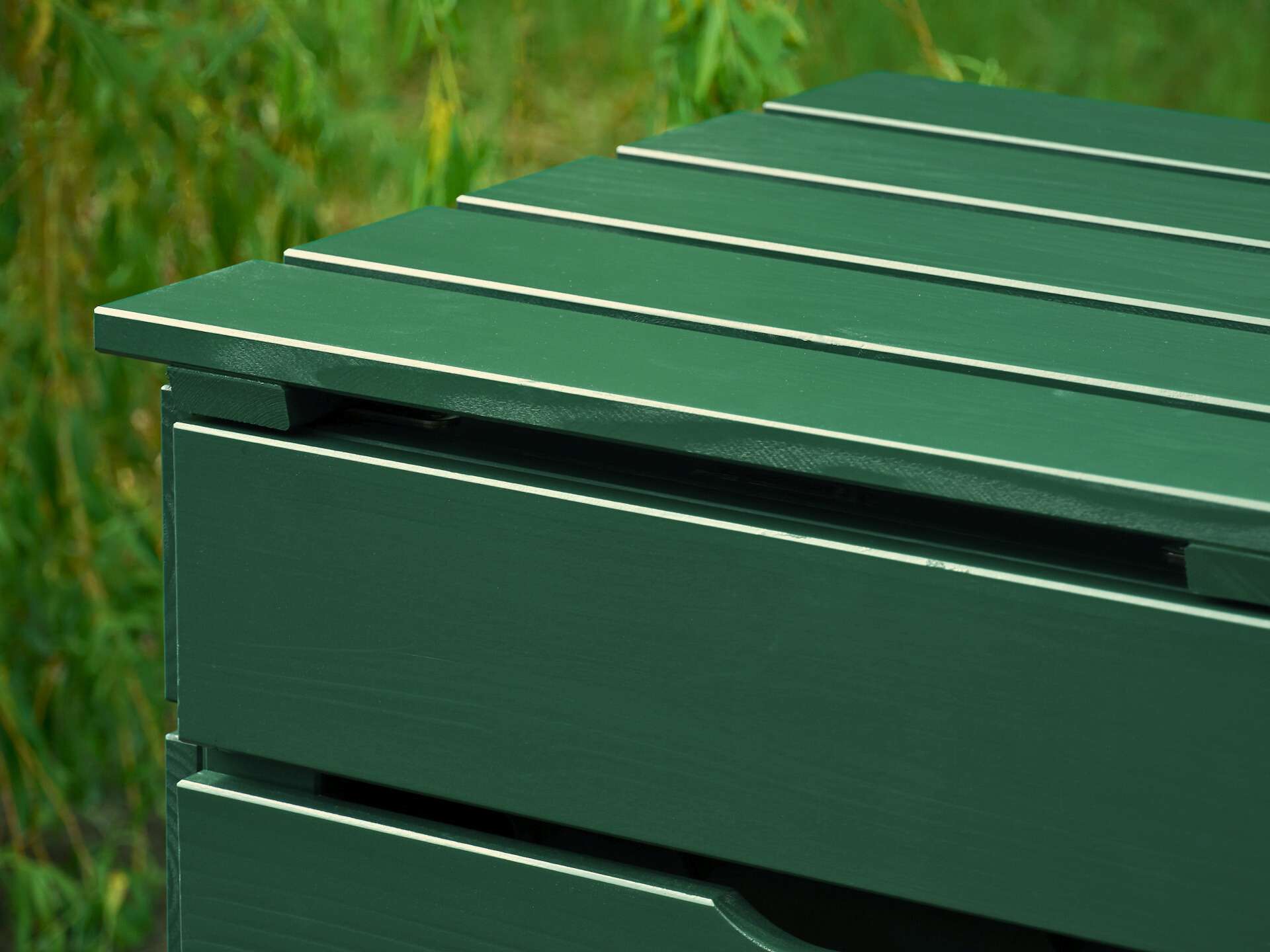 Detailansicht von Deckel und Türsegment an der moosgrünen Mülltonnenbox